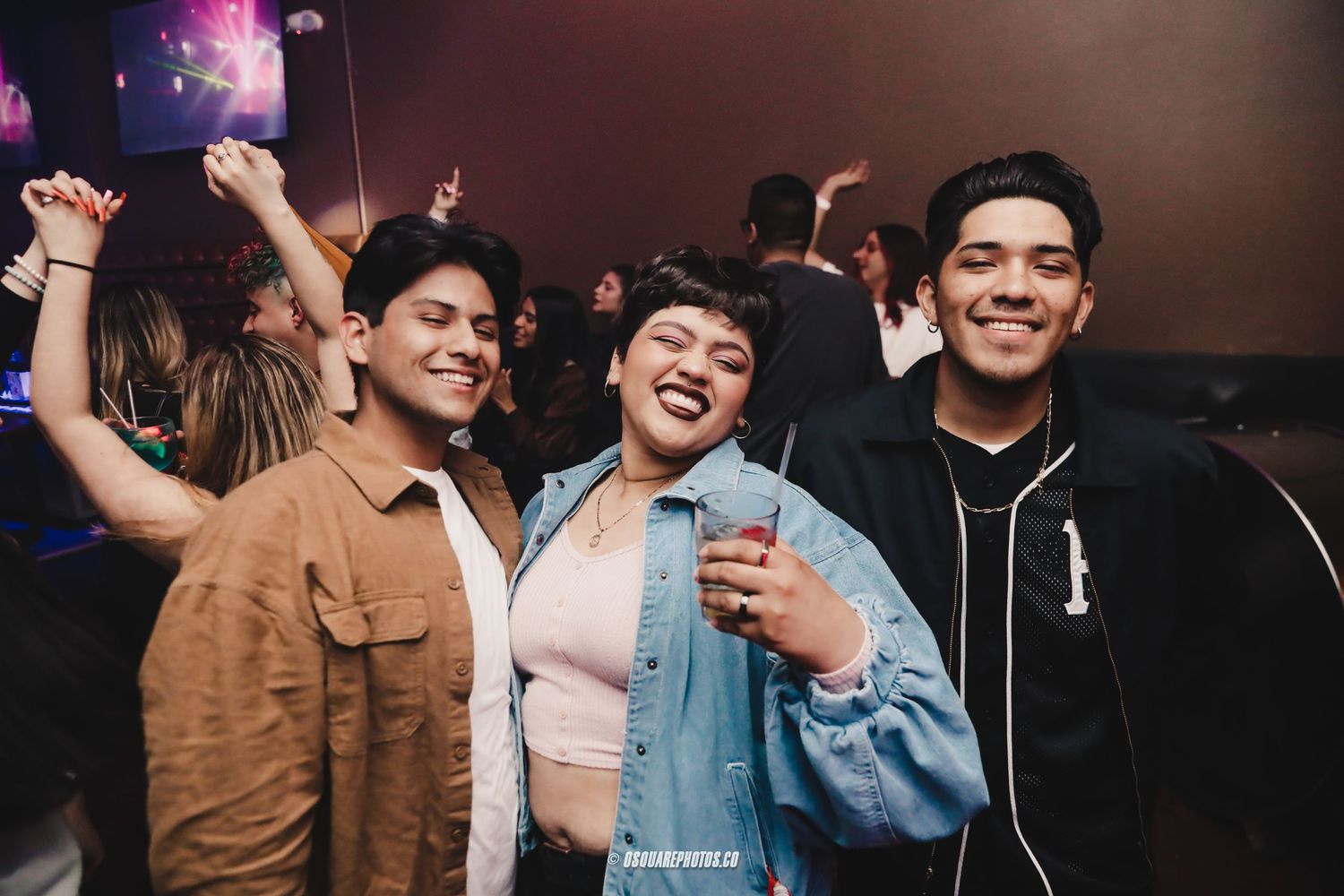 Friends enjoying drinks and laughing together at a nighttime social gathering.