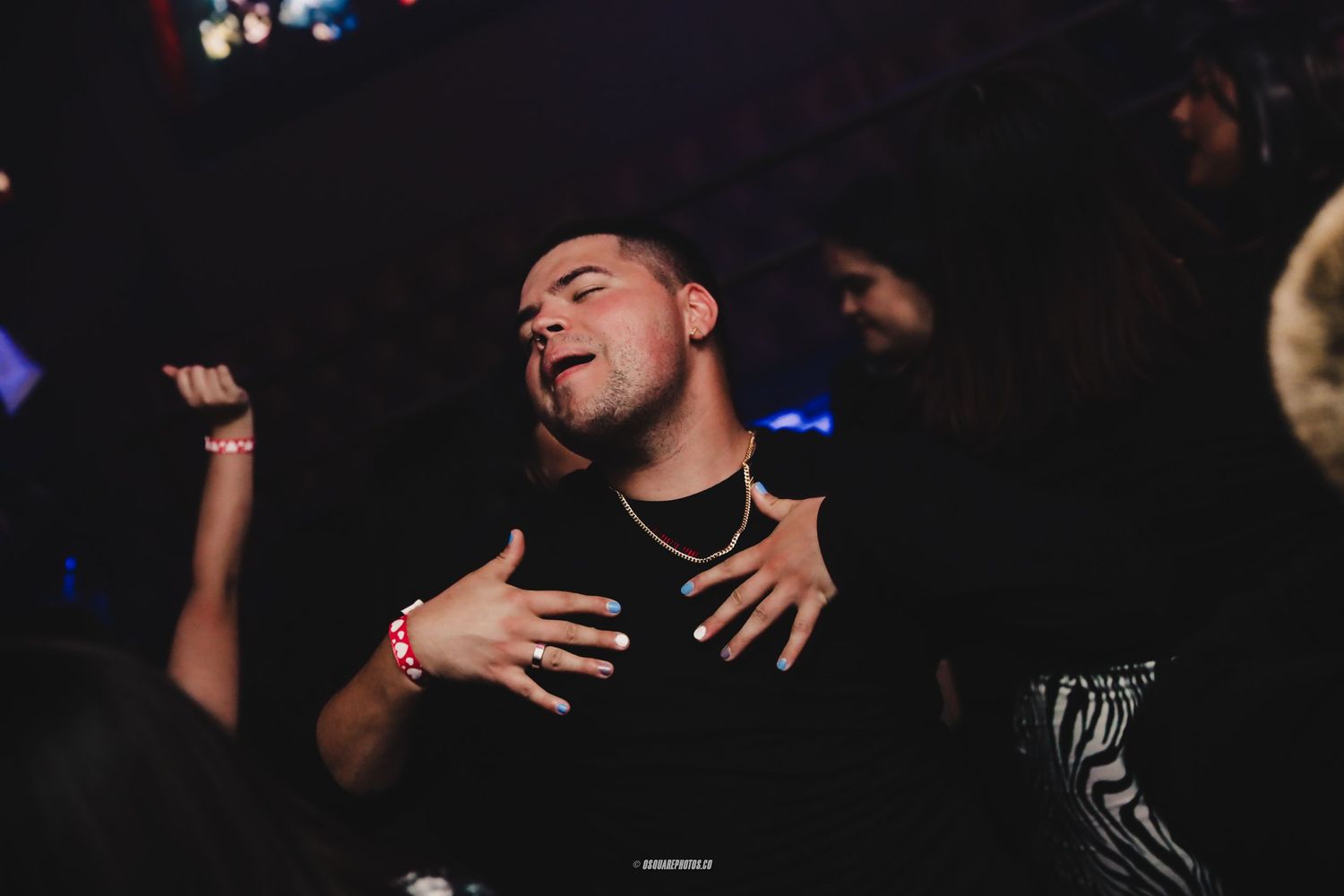 Person singing passionately in dark club setting with dramatic expression.