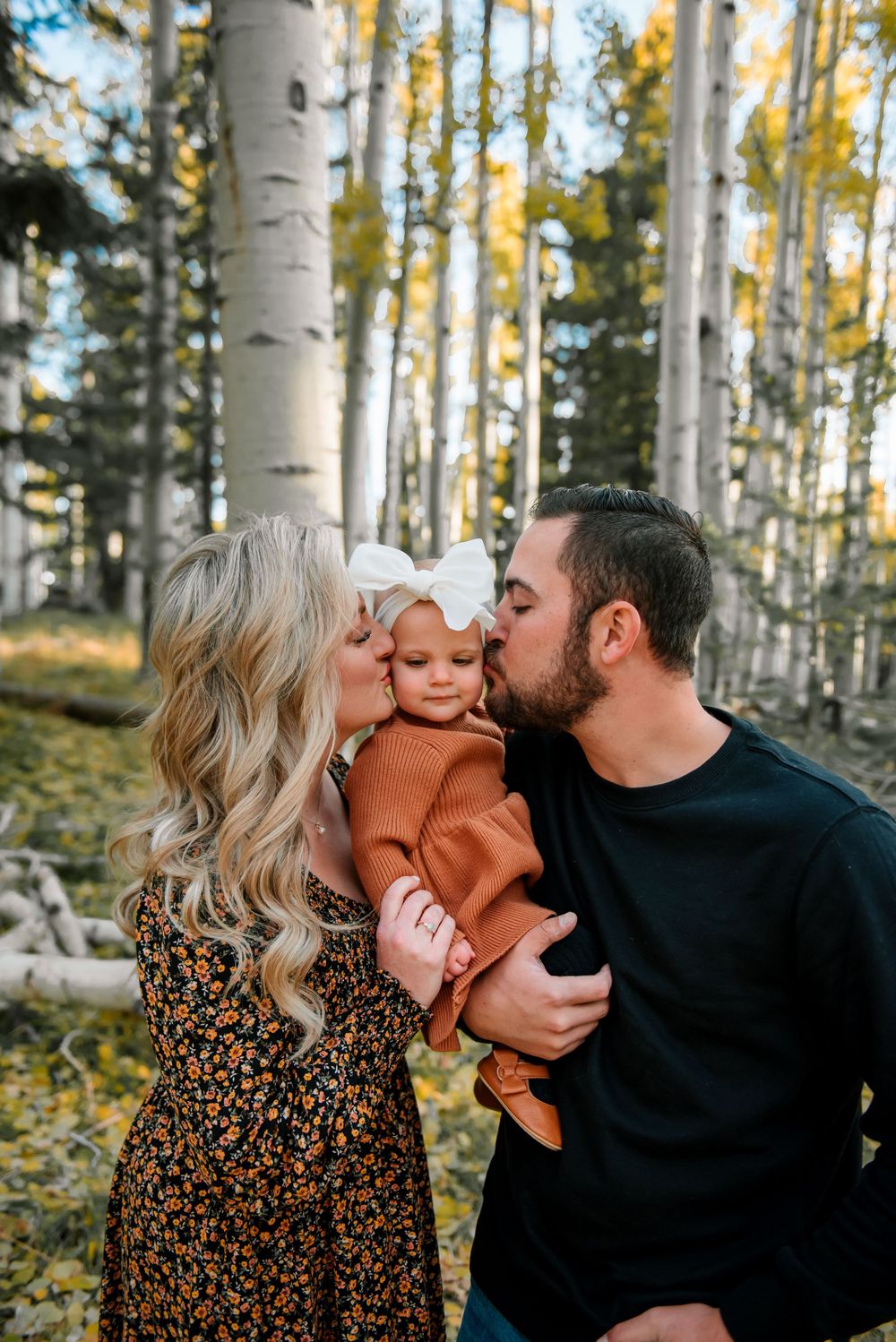 Family sharing tender moments together in an autumn aspen grove.