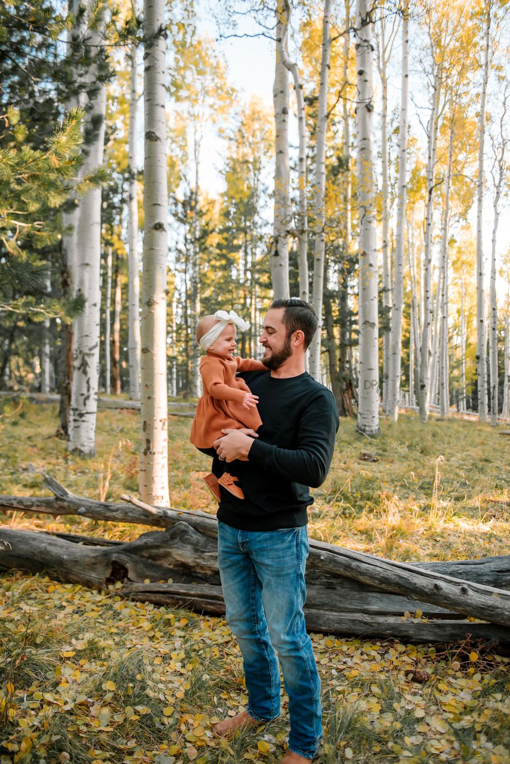 Playful interactions between family members in an autumn forest setting.