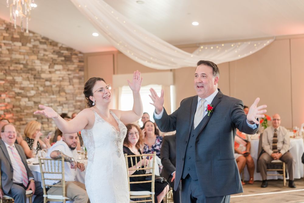 Joyful celebration moment during wedding reception in stone-walled venue.