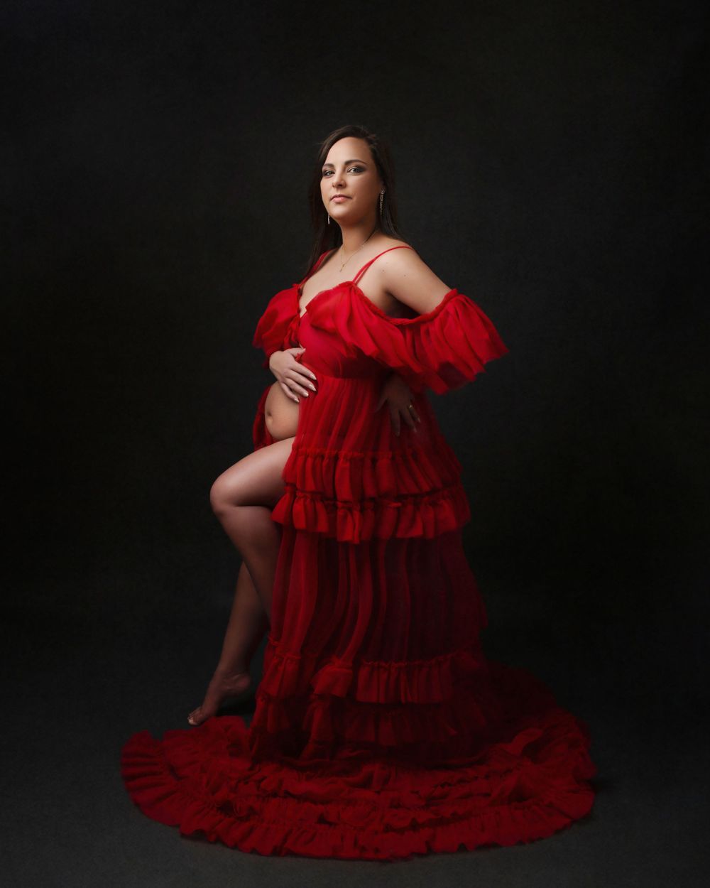 Maternity dress expecting mum sitting on a chair in a long tulle dress portrait photo