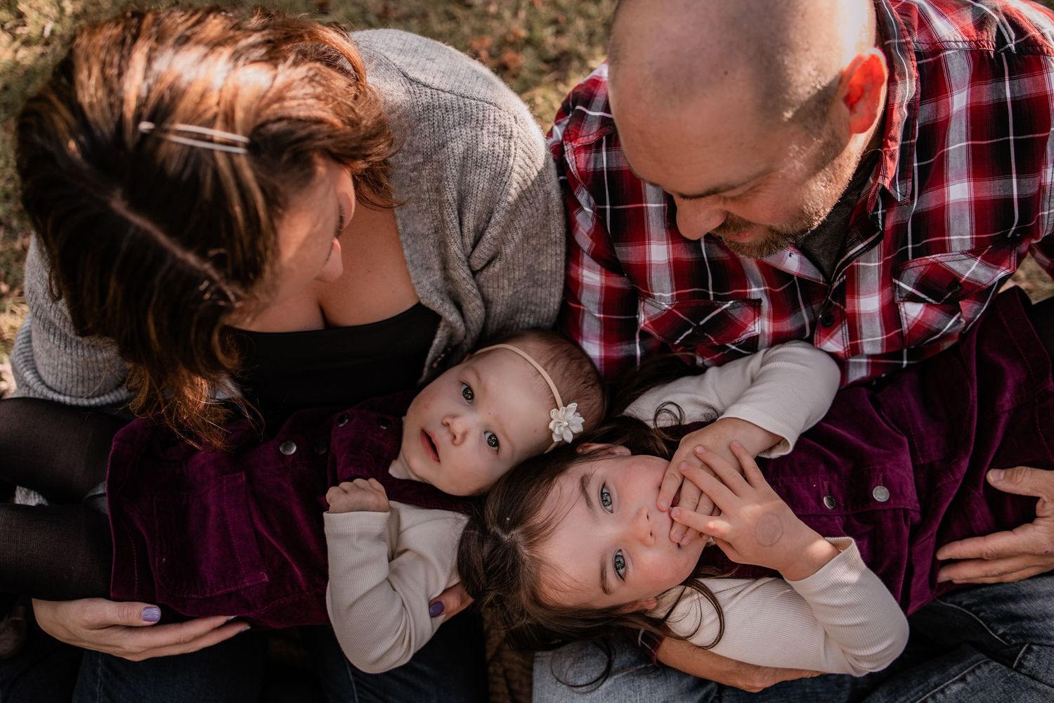 Family sharing intimate playful moment together during outdoor photo session.