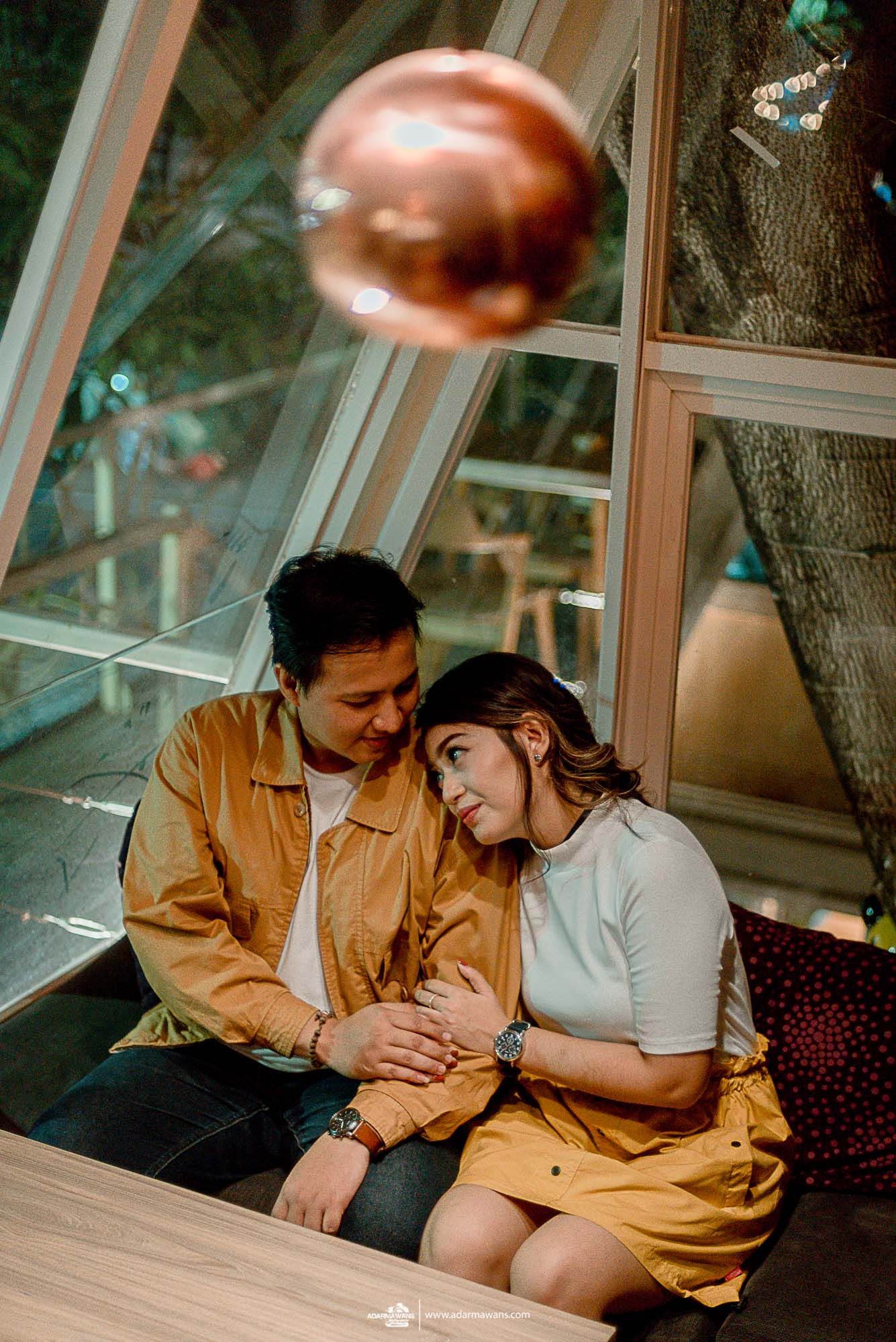 A tender moment between a couple in a cozy indoor setting with warm lighting.