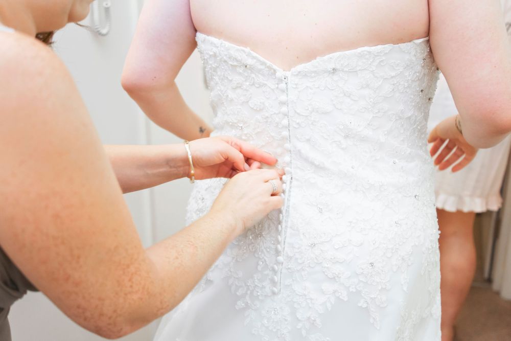 The bride having her dress tied up