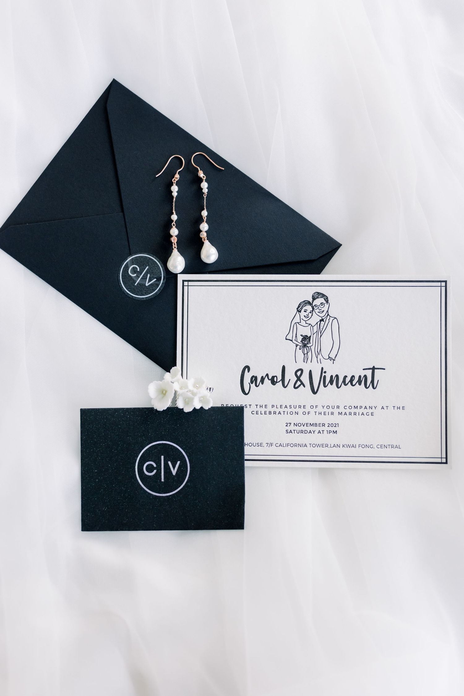 Elegant wedding invitation suite in black and white with pearl earrings.