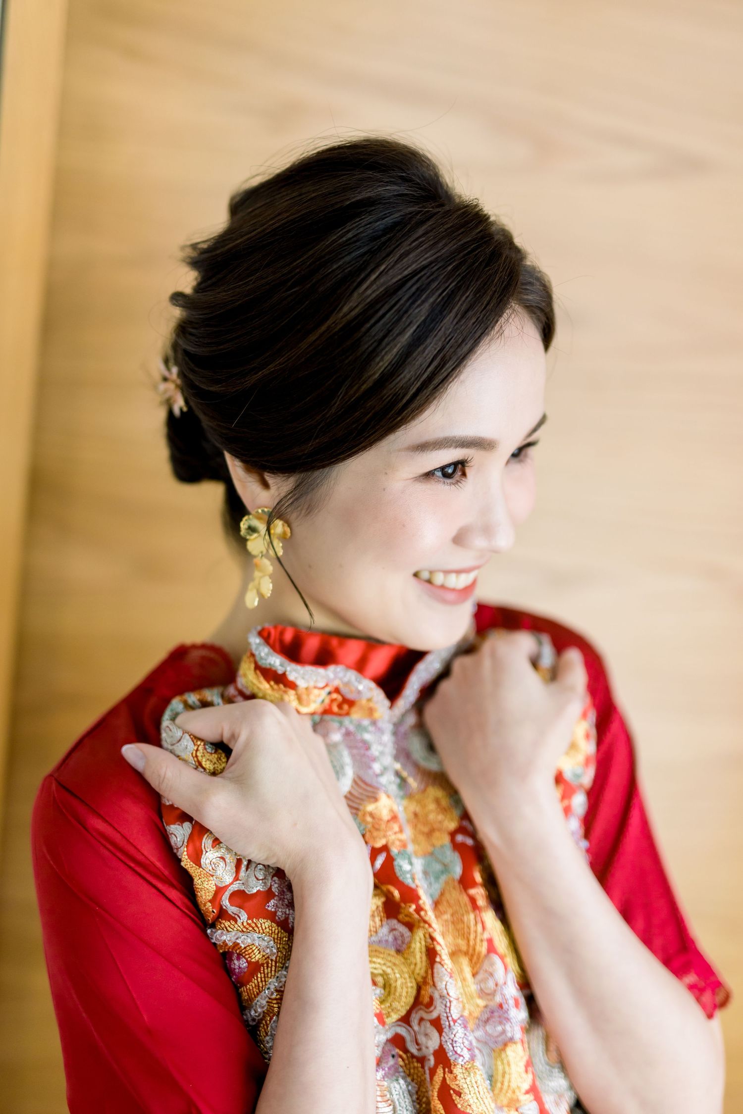 Portrait of woman in traditional red Chinese dress with elegant updo.