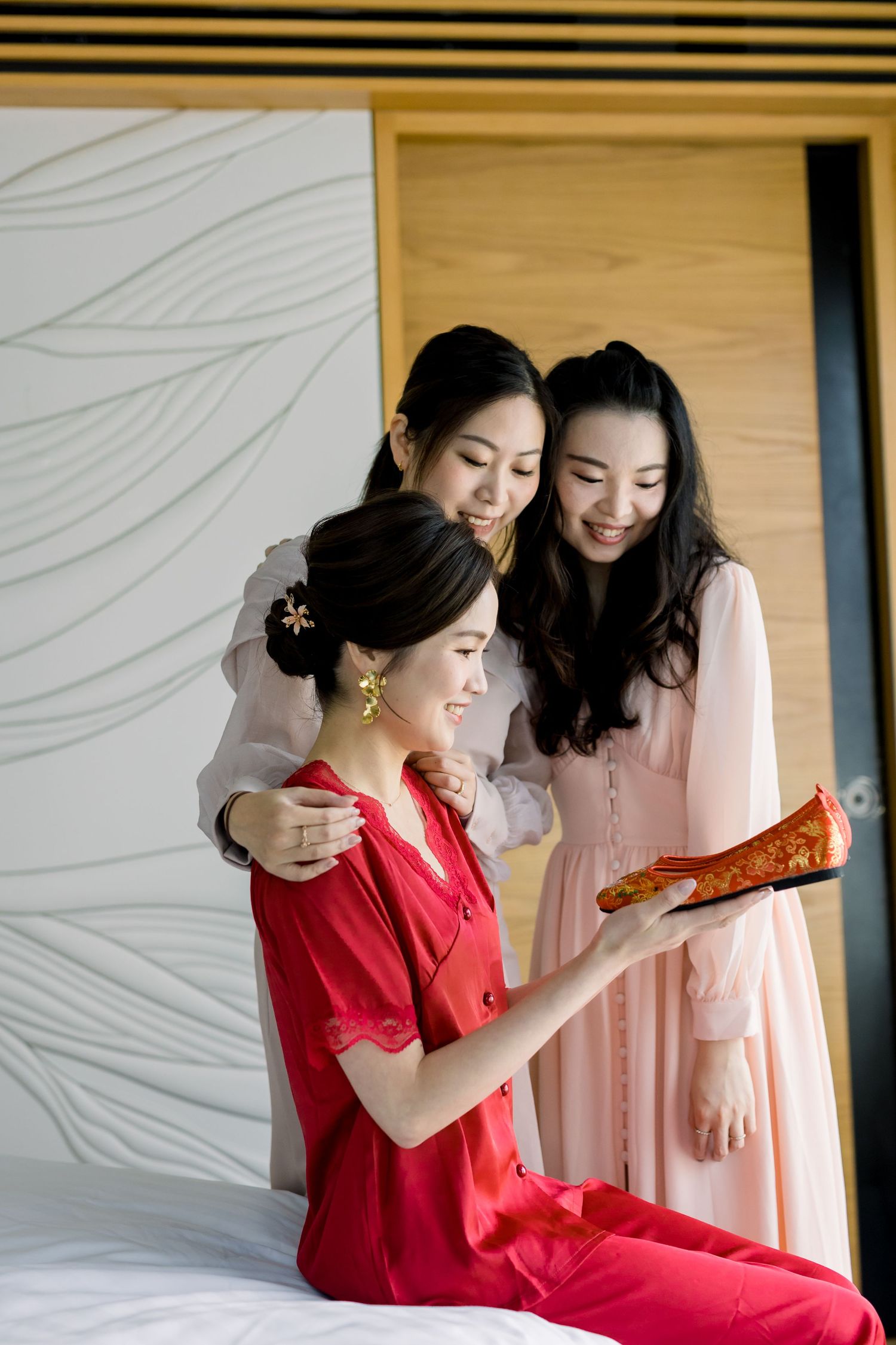 Getting ready moment with bridesmaids admiring traditional shoes.