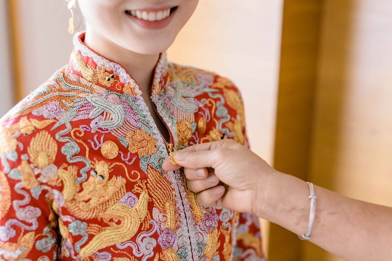 Close-up detail of red and gold floral traditional Chinese dress.