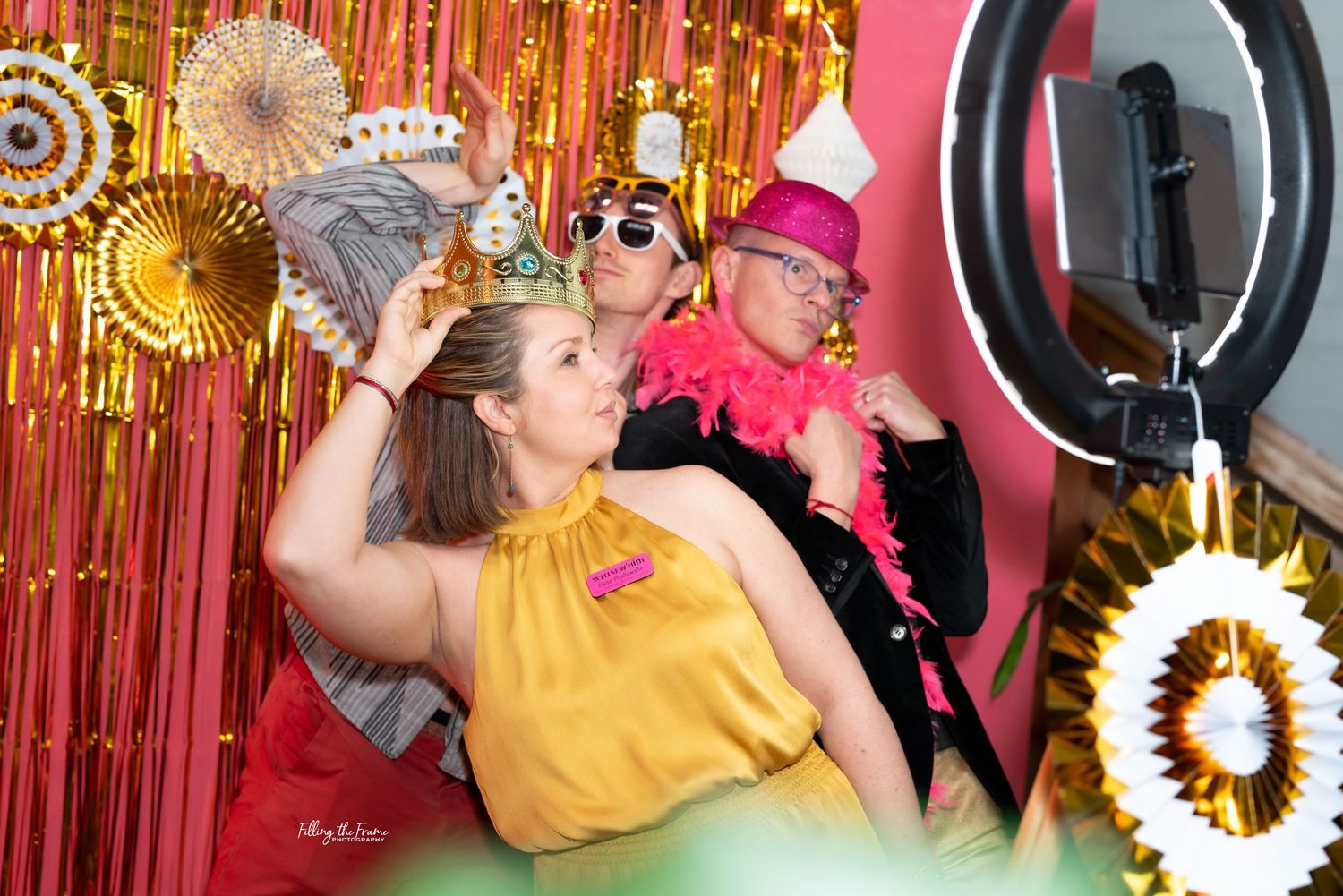 Party photo booth scene with gold fringe curtain backdrop and festive props.