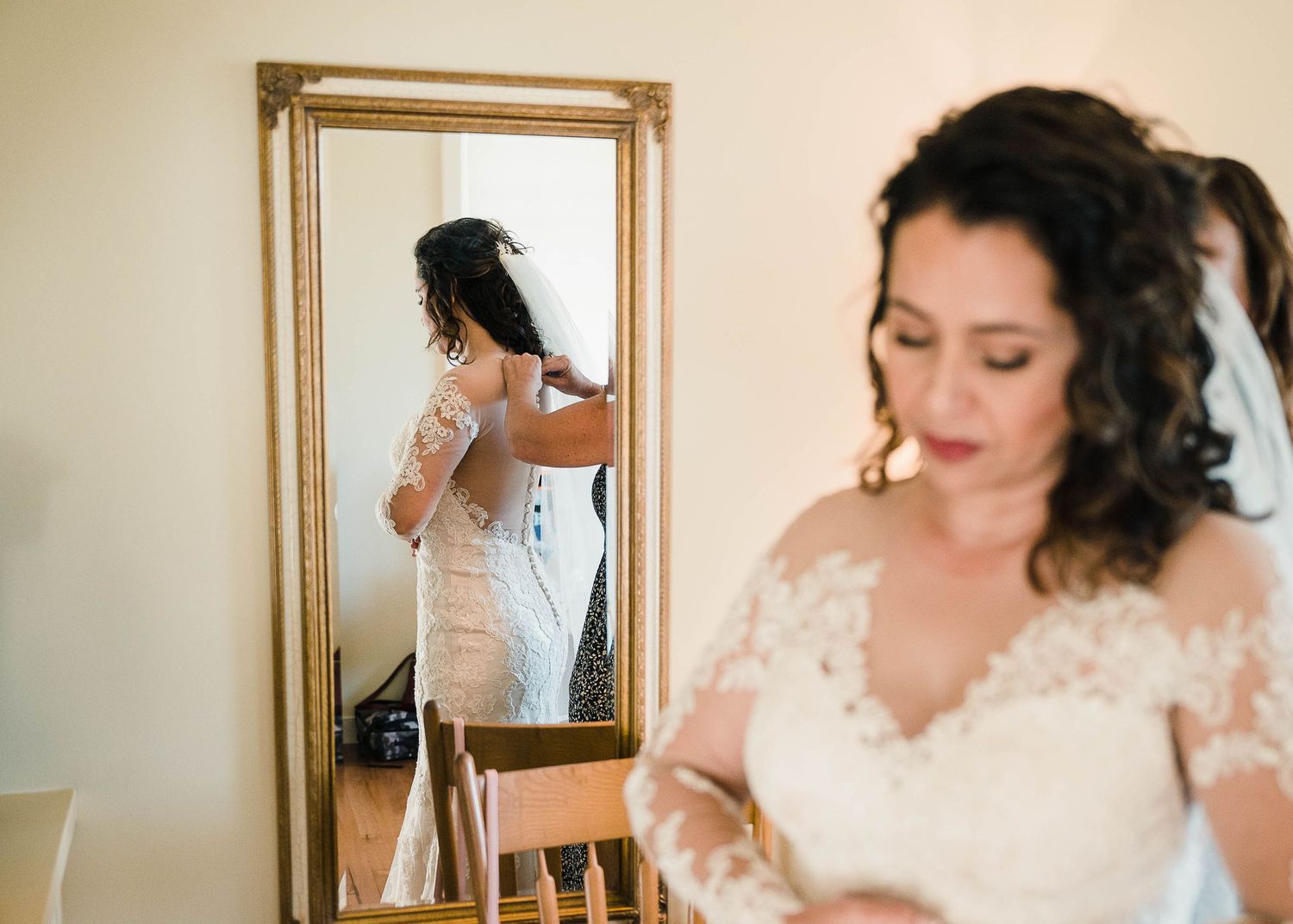 Elegant bridal preparation scene with vintage mirror reflection and lace details.
