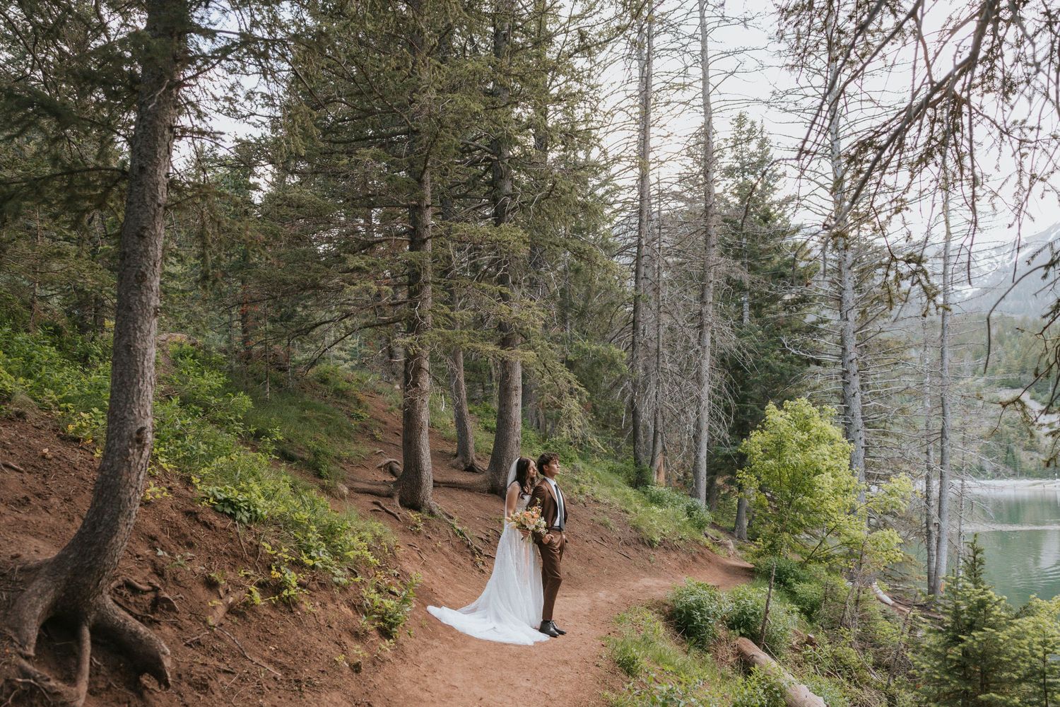 A bride and groom pose in the forest near Salt Lake City Utah for their affordable wedding photographer.