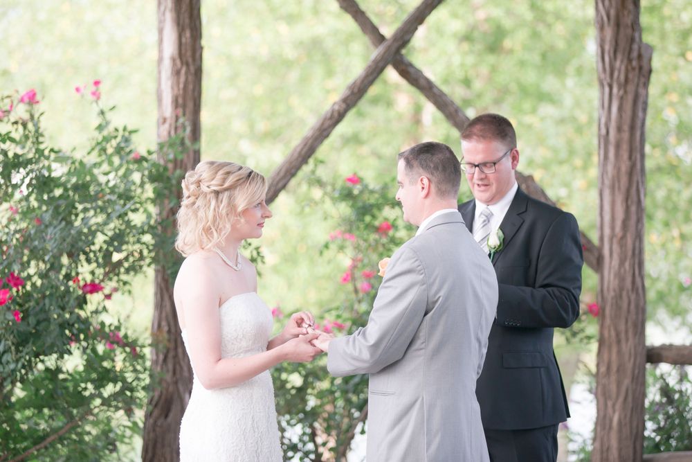 Intimate outdoor wedding ceremony with couples exchanging vows under wooden pergola.