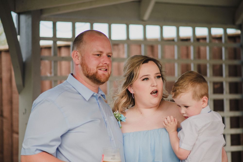 A sweet family moment captured under a gazebo at an outdoor event.