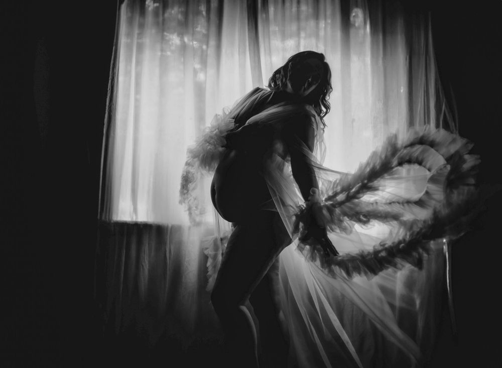 Black and white silhouette dancing with flowing fabric in dramatic motion.