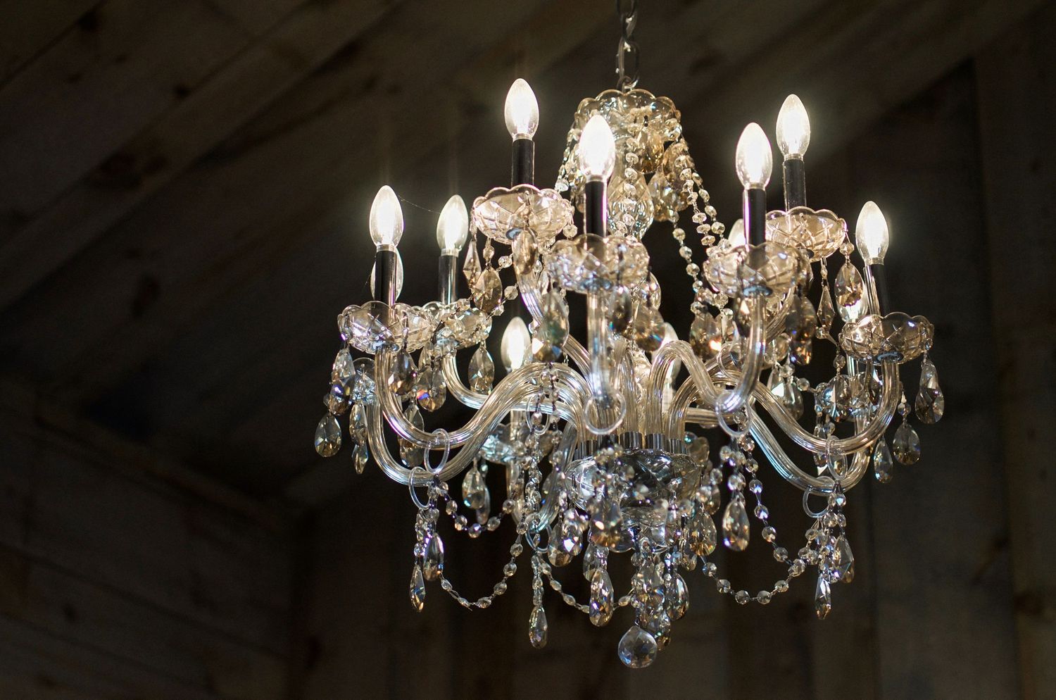 Elegant crystal chandelier with multiple tiers of lights hanging from ceiling.