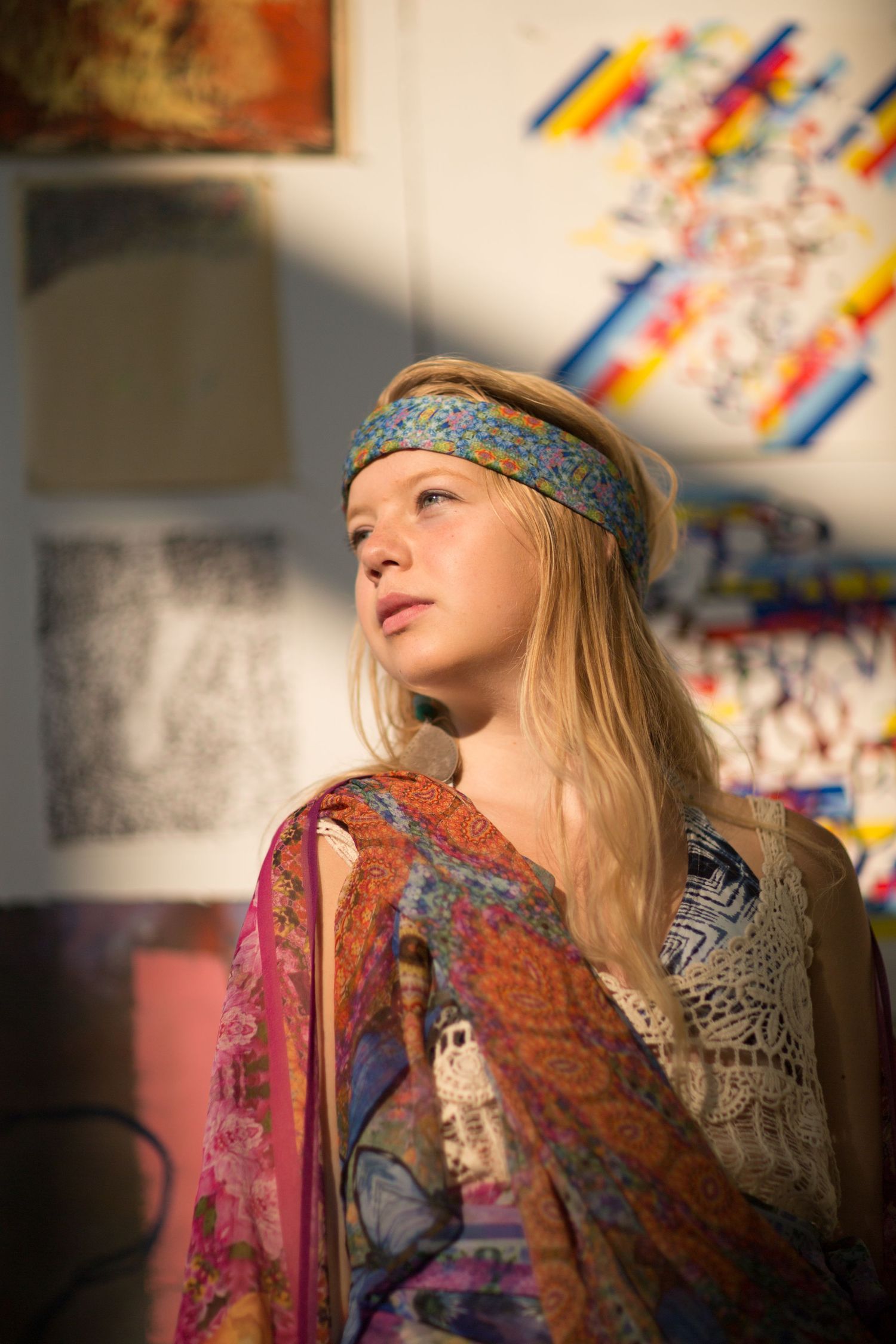 Artistic portrait in bohemian style with soft natural lighting and colorful decor.