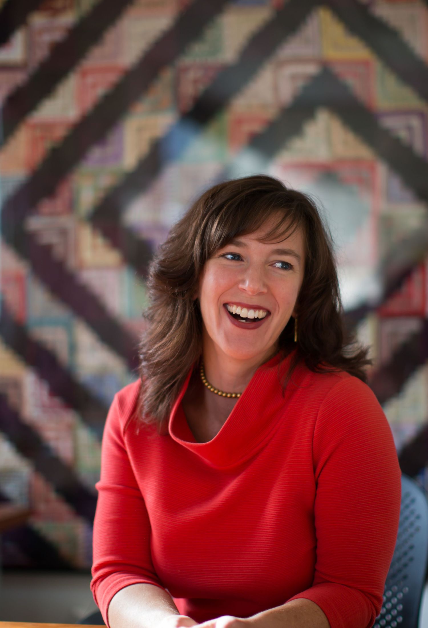 A series of expressive portrait shots featuring someone in a bright red turtleneck sweater against a patterned background.