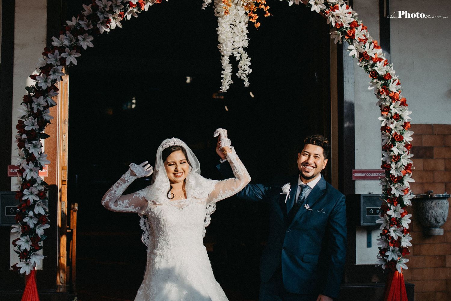 Wedding ceremony under a floral arch with romantic lighting and decorative elements.