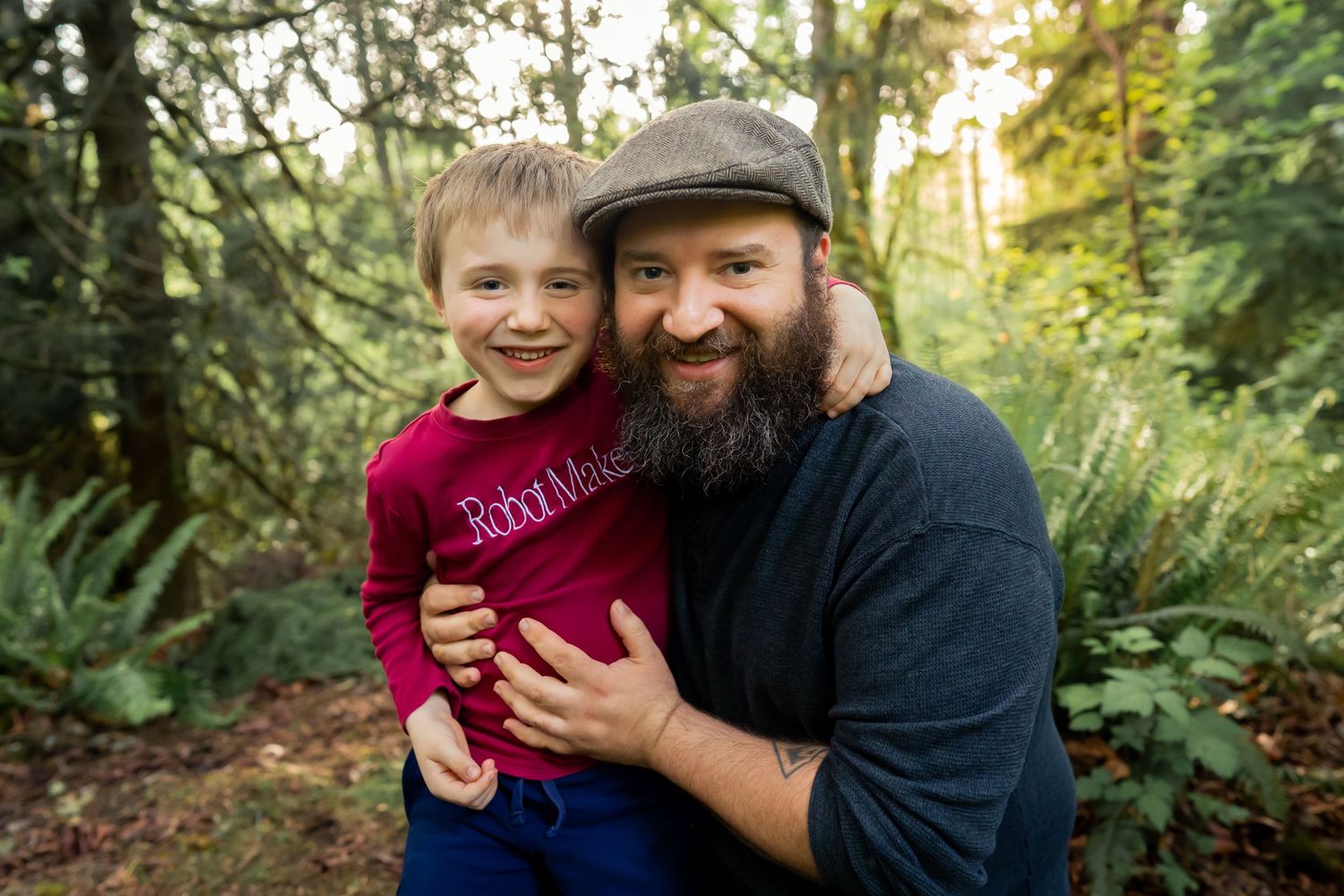 A playful outdoor autumn photoshoot in a wooded area with warm golden sunlight filtering through the trees.