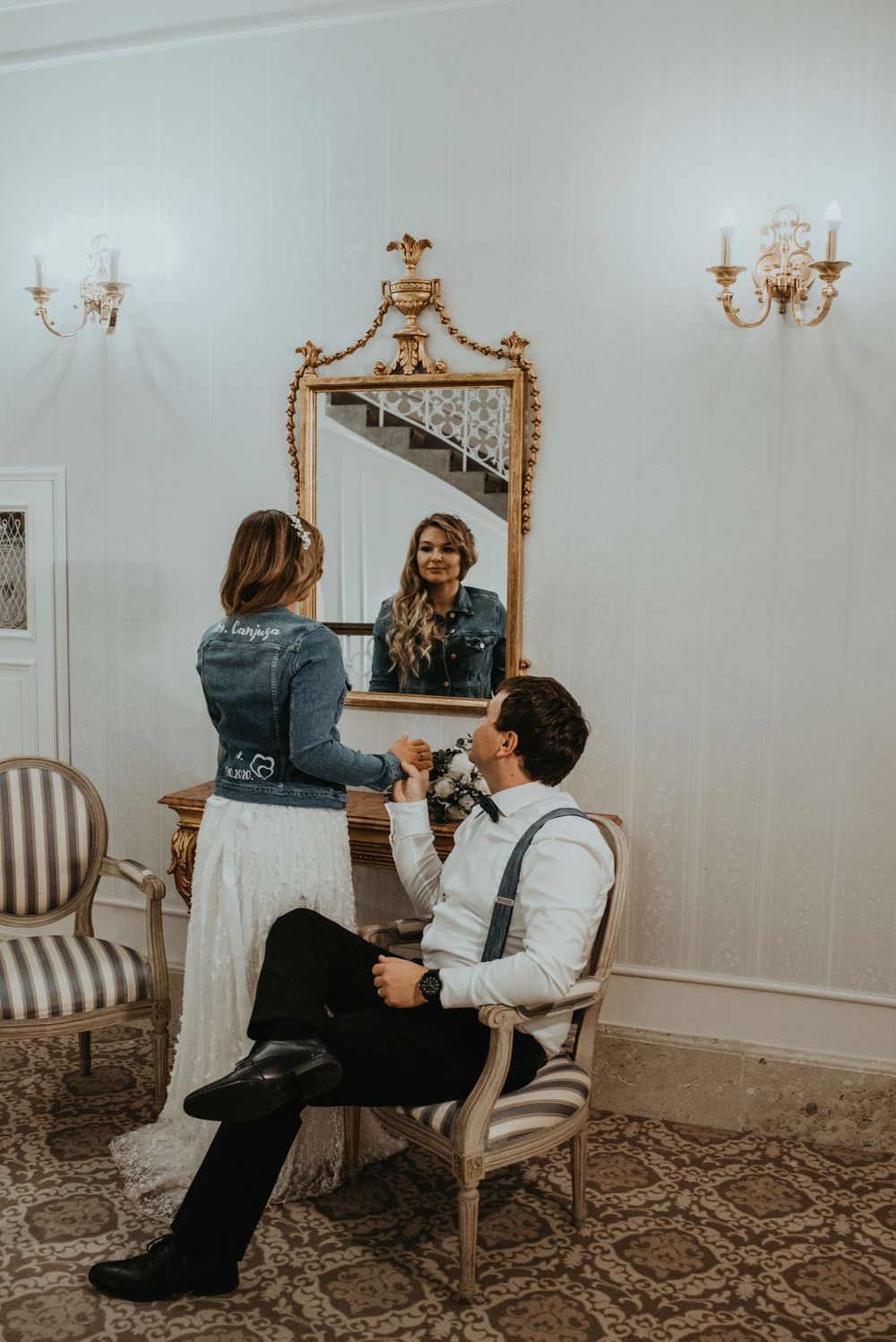 Candid moment captured in an elegant room with an ornate gold mirror and traditional furnishings.