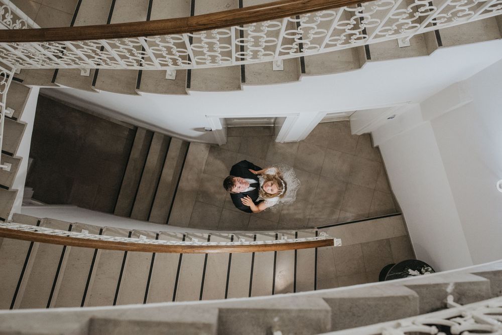 Aerial view of a spiral staircase with ornate white railings in a historic building.