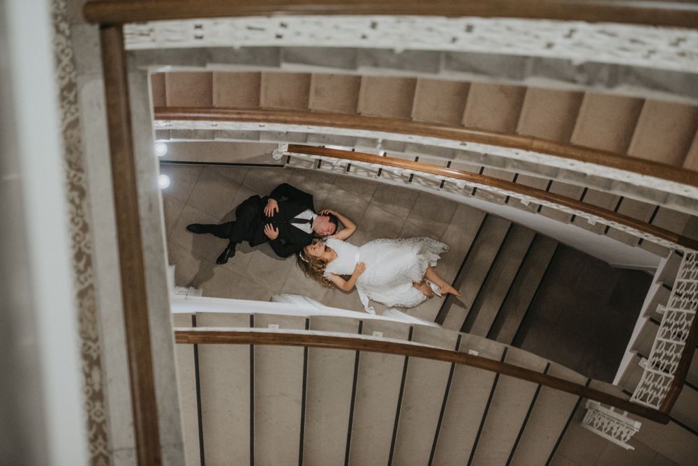 Overhead shot of a grand spiral staircase with decorative white railings and carpeted steps.