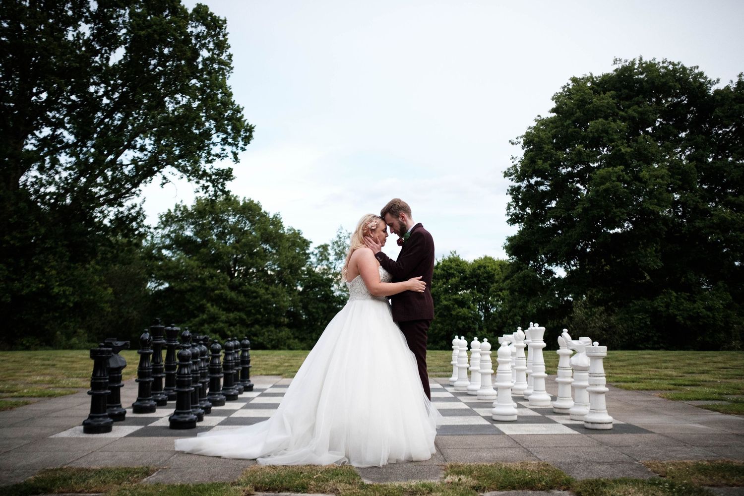 Elegant portrait of a bride and groom at the centre of a giant chess board at The Manor Elstree in Borehamwood.