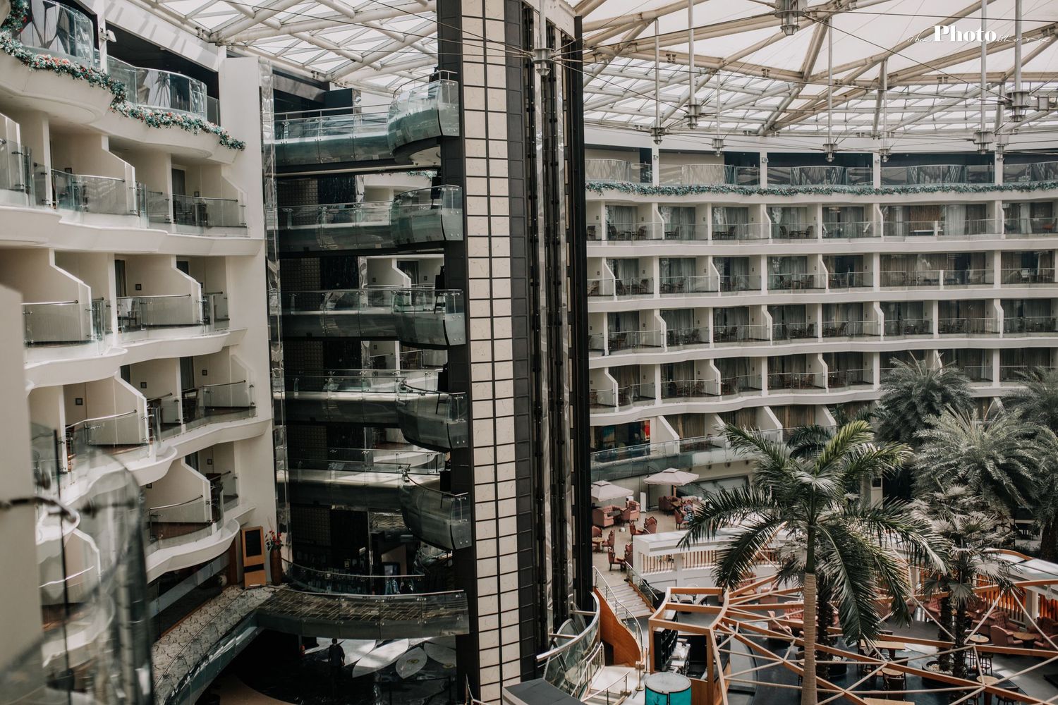 Modern mall architecture with glass ceiling and multiple tiered levels visible from above.