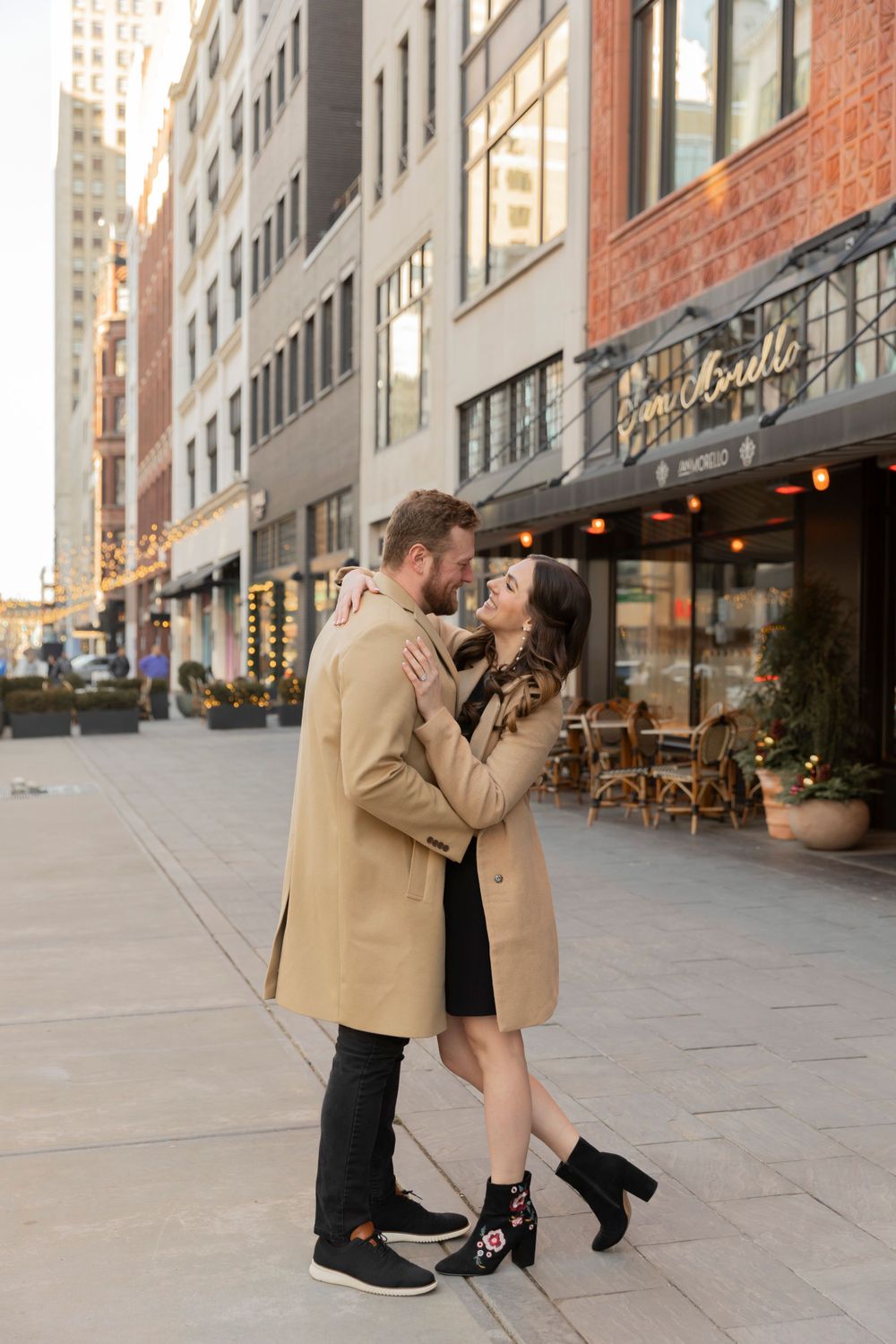 couple dancing and smiling at each other in winter on Woodward in downtown Detroit