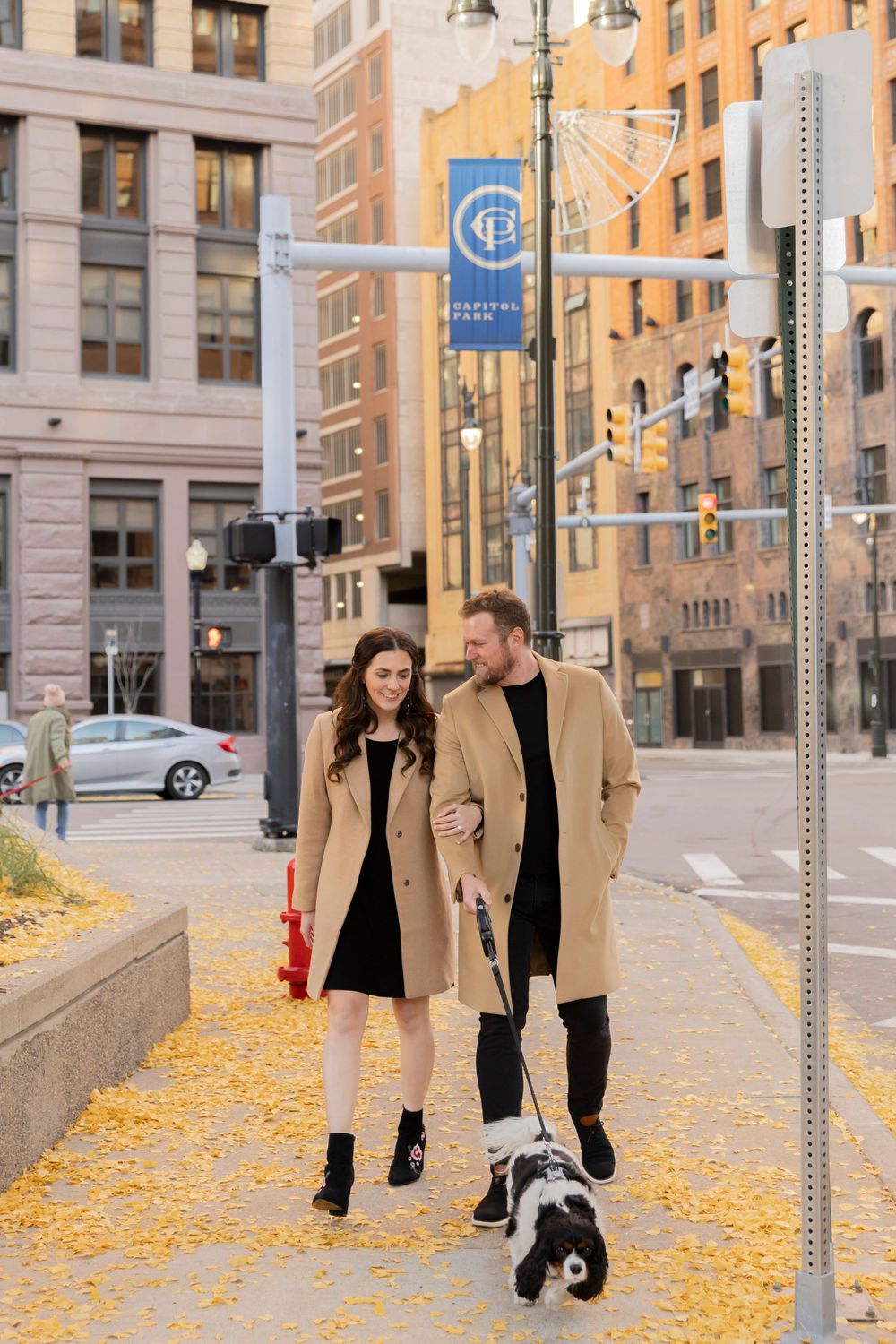 couple walking their dog in downtown detroit near capital park