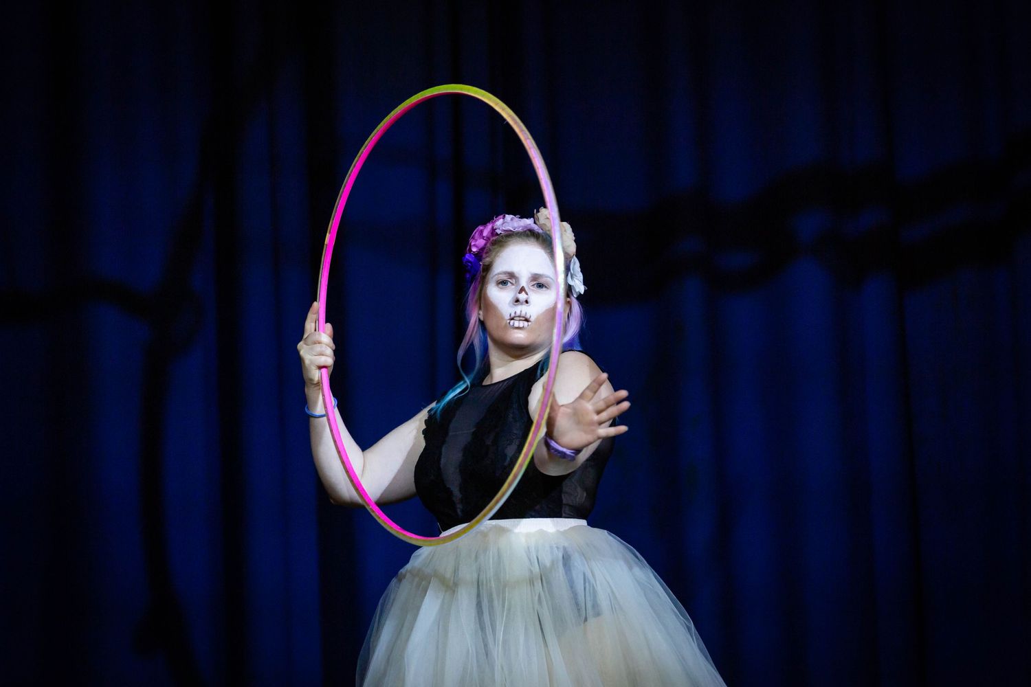event photography of a Circus performer using a hoop on stage wearing a net skirt and halloweenmake up