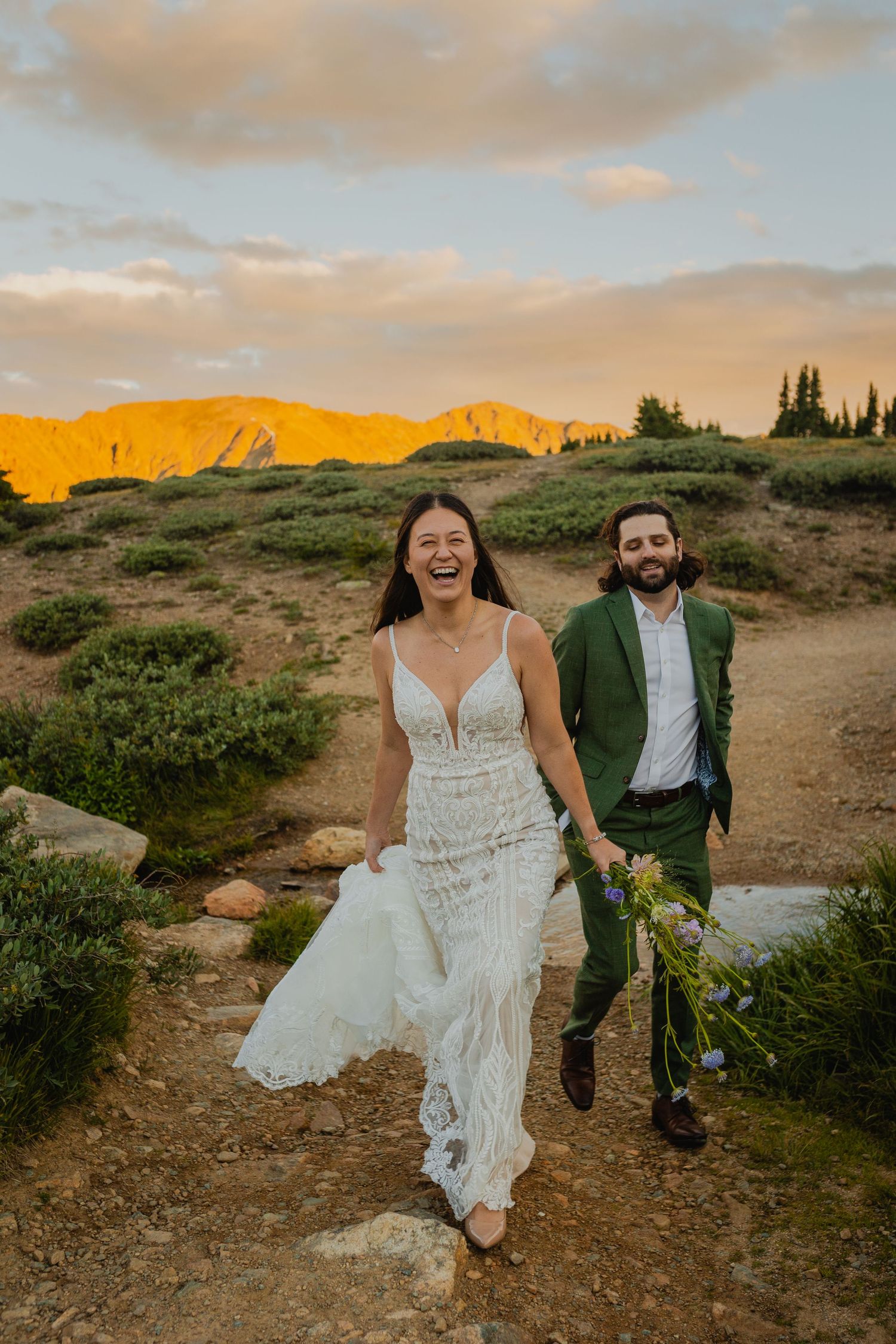 Couple walking hand in hand with a breathtaking mountain vista in the background on Loveland Pass