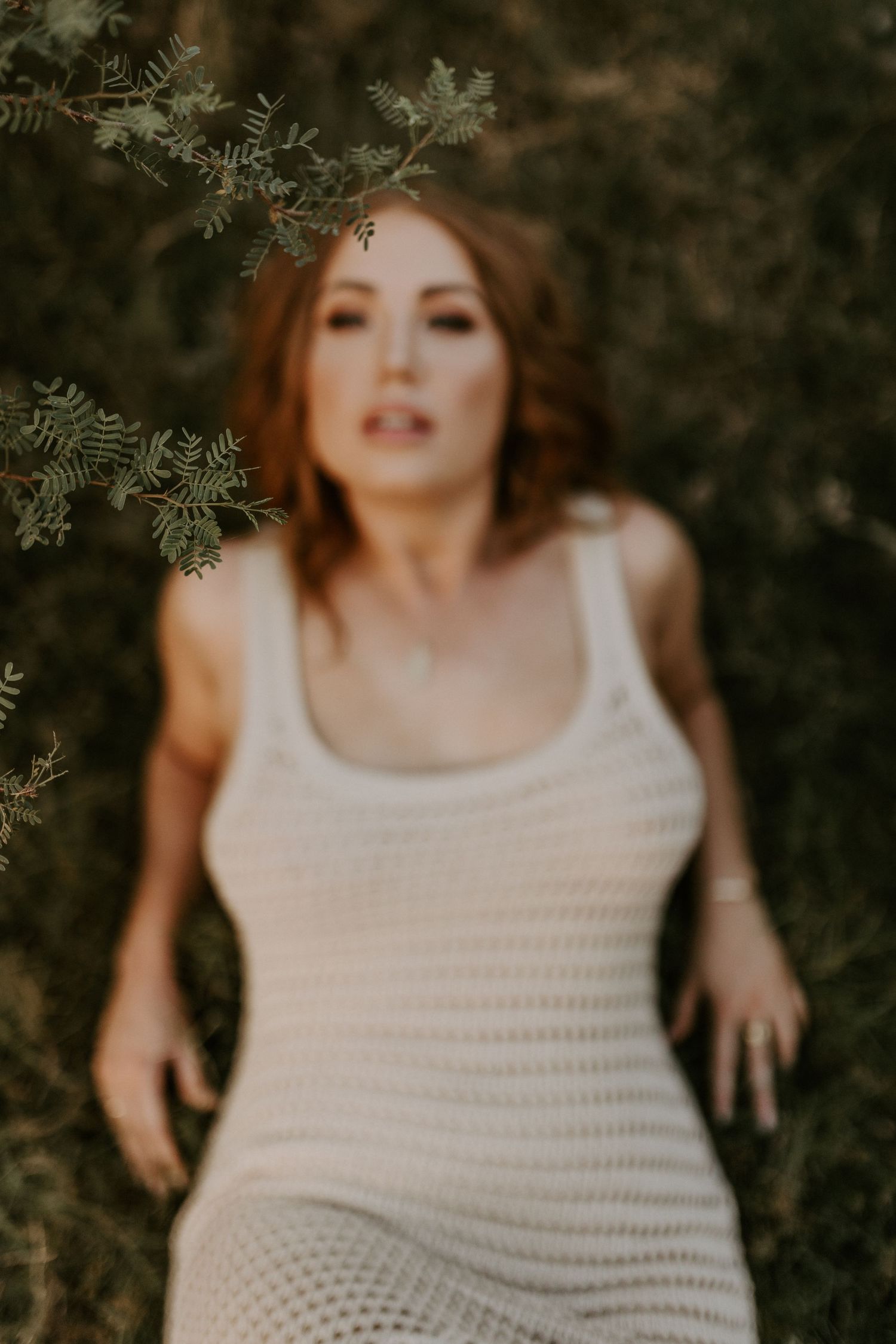 Woman laying in grass with focus on leaves in Mount Isa