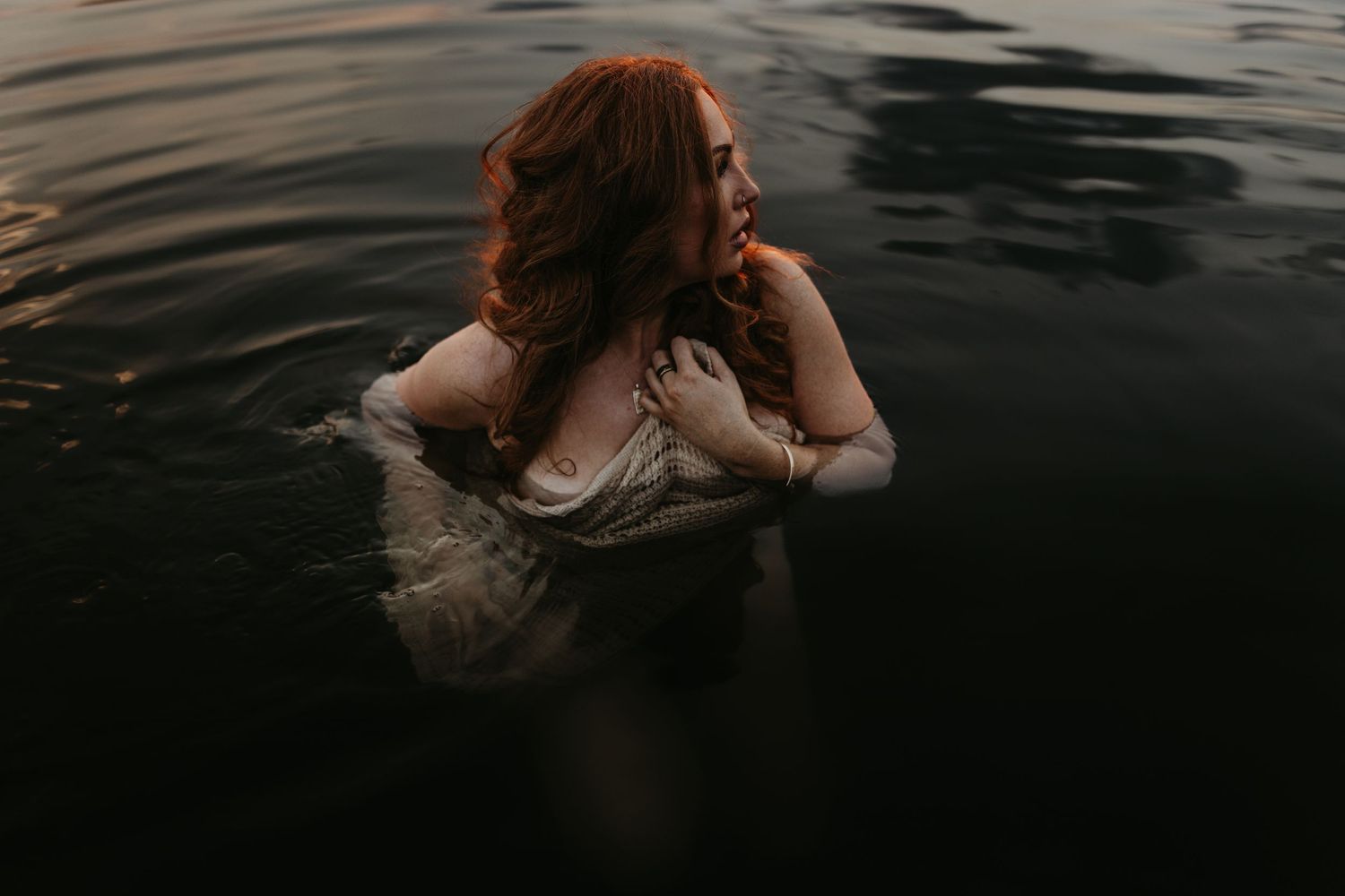 Woman caressing her face in water at Lake Moondarra, Mount Isa