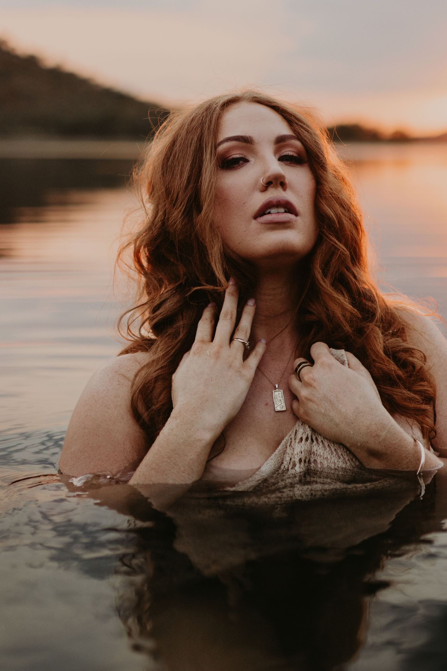 Woman caressing her face in water at Lake Moondarra, Mount Isa
