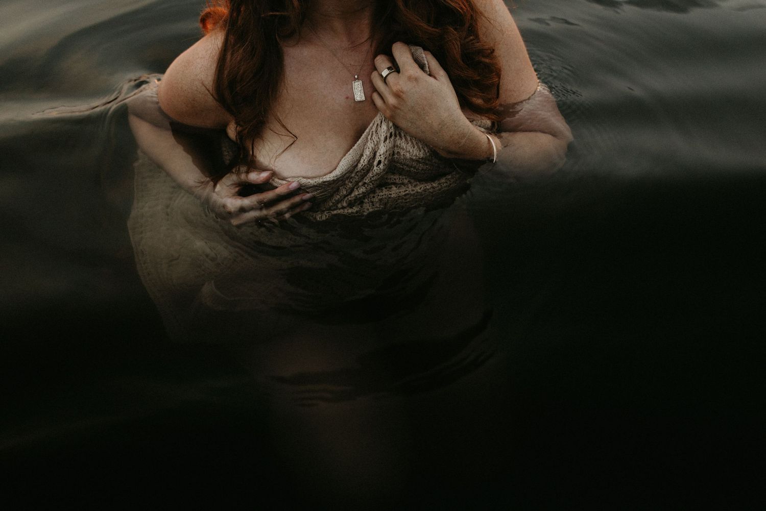 Woman caressing her face in water at Lake Moondarra, Mount Isa