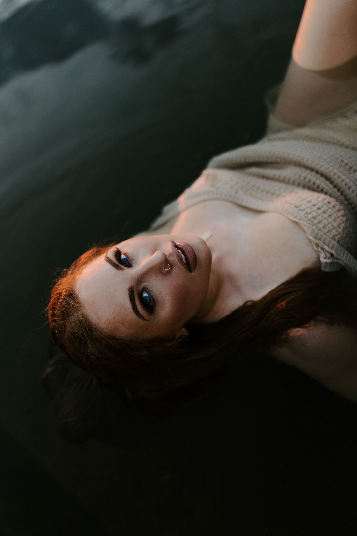 Woman caressing her face in water at Lake Moondarra, Mount Isa