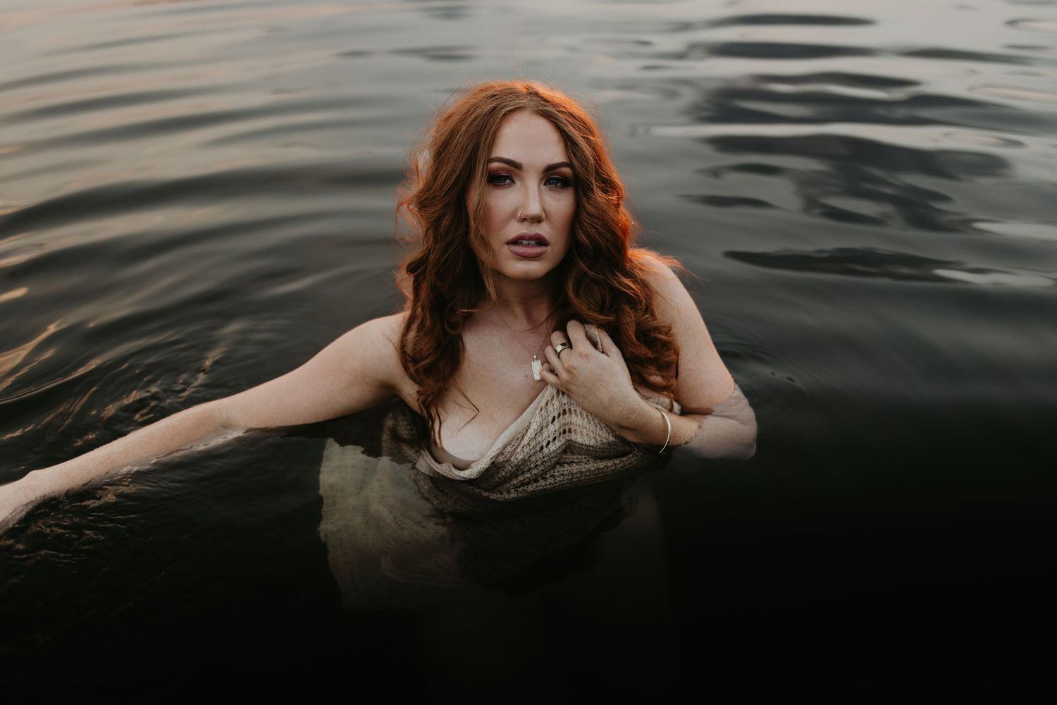 Woman caressing her face in water at Lake Moondarra, Mount Isa