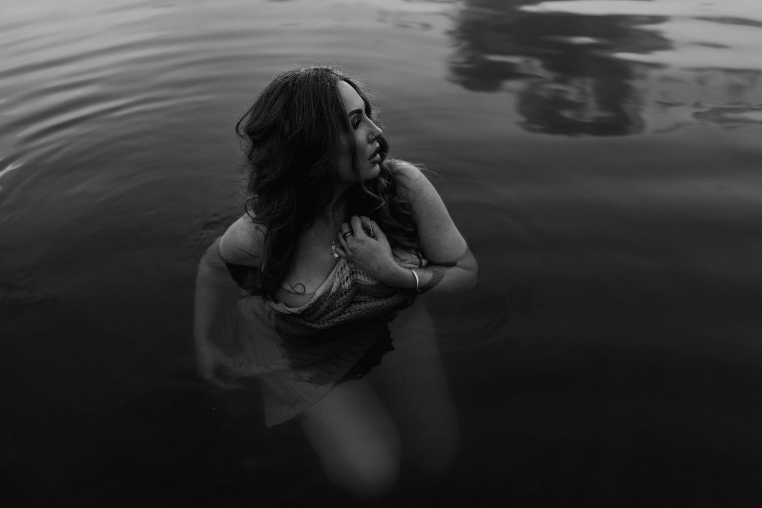 Woman caressing her face in water at Lake Moondarra, Mount Isa