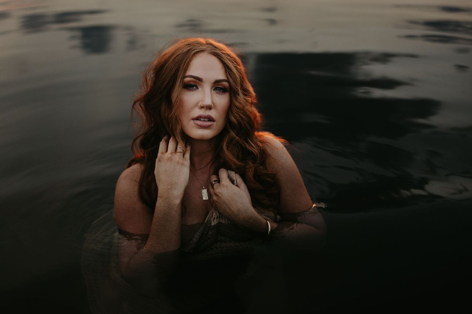 Woman caressing her face in water at Lake Moondarra, Mount Isa