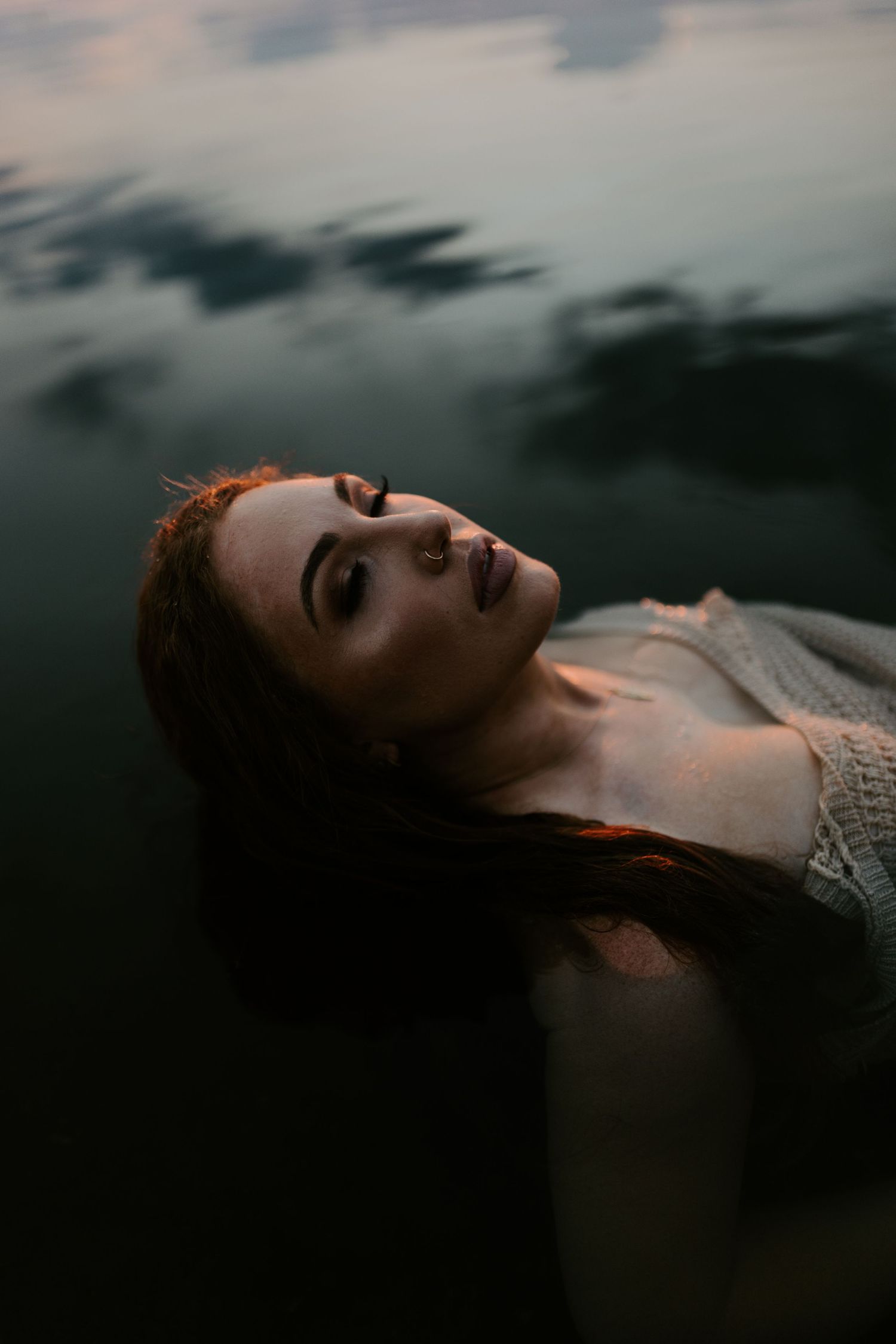 Woman caressing her face in water at Lake Moondarra, Mount Isa