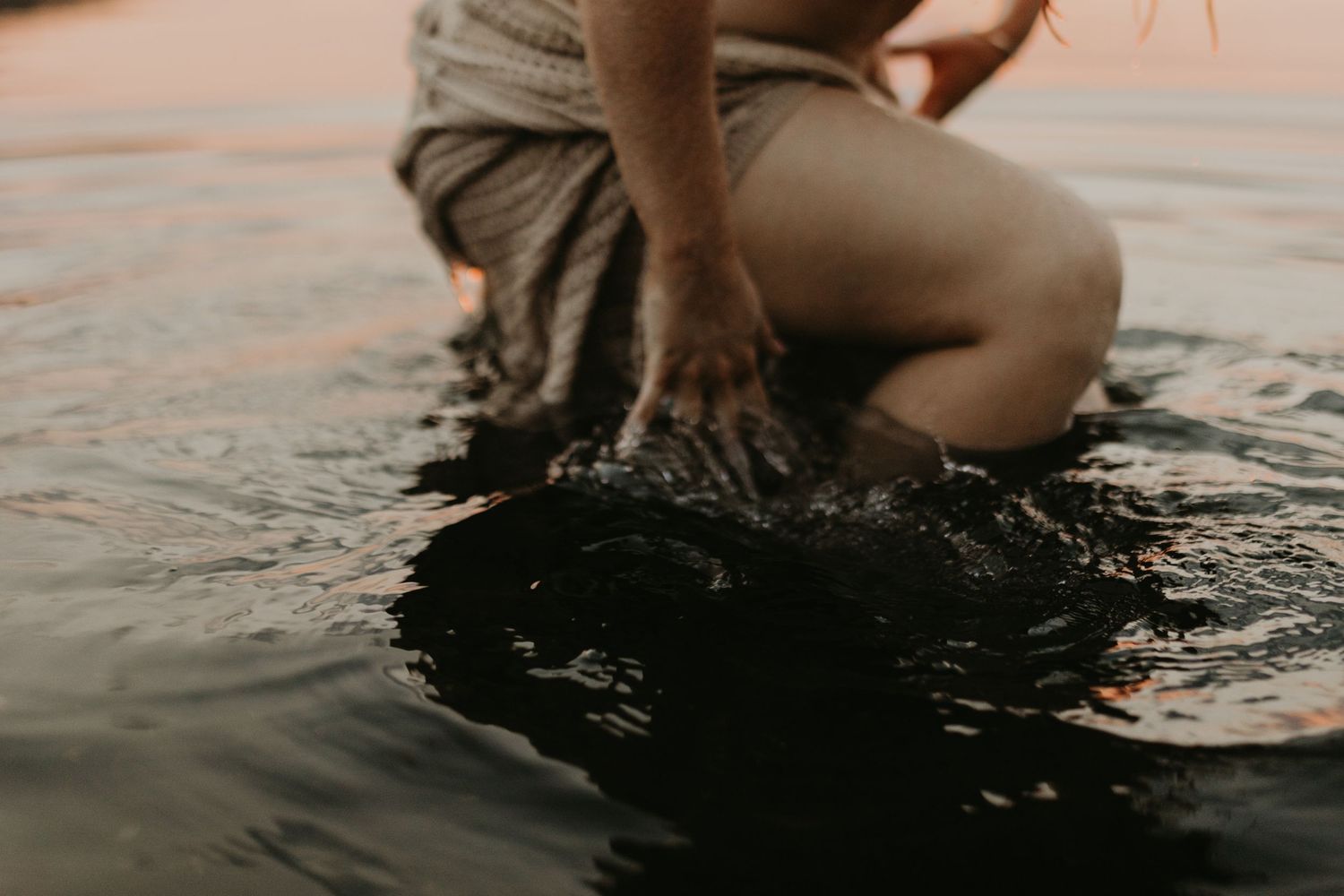 Woman caressing her face in water at Lake Moondarra, Mount Isa