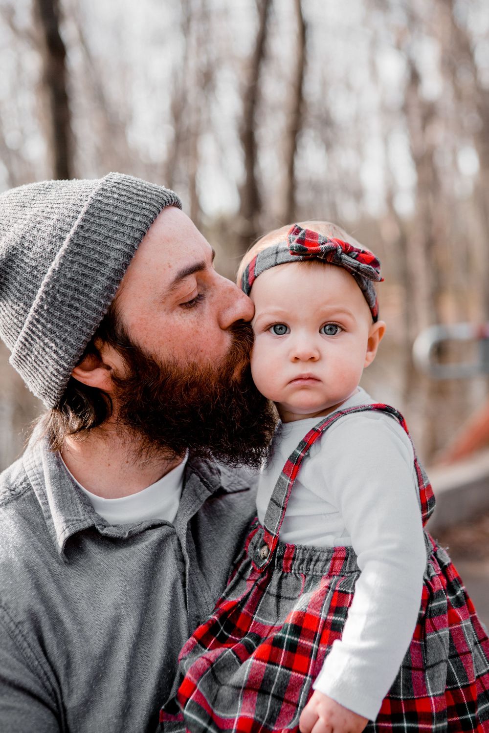 A winter family photoshoot features cozy plaid and knit outfits.