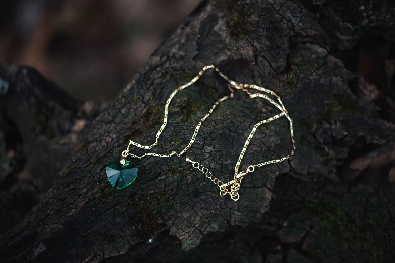 Delicate silver necklace with turquoise pendant displayed on dark textured stone.