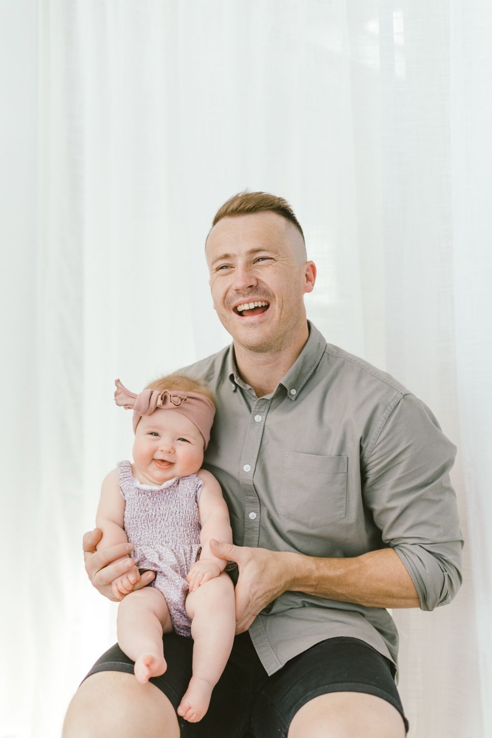 Happy moment captured during family photo session against white background.
