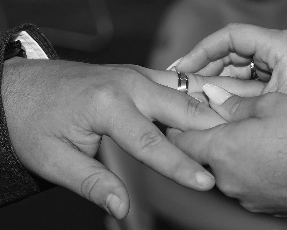 Close-up series of hands exchanging rings during a wedding ceremony.