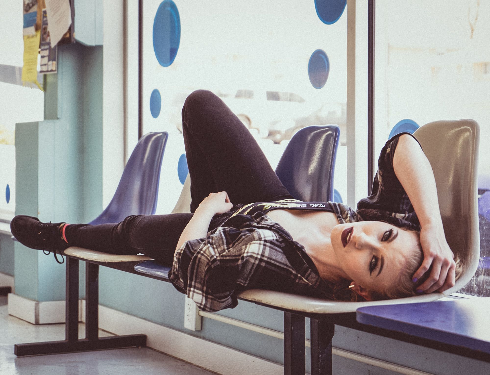 Captivating model laying in a waiting area dressed in casual chic clothing