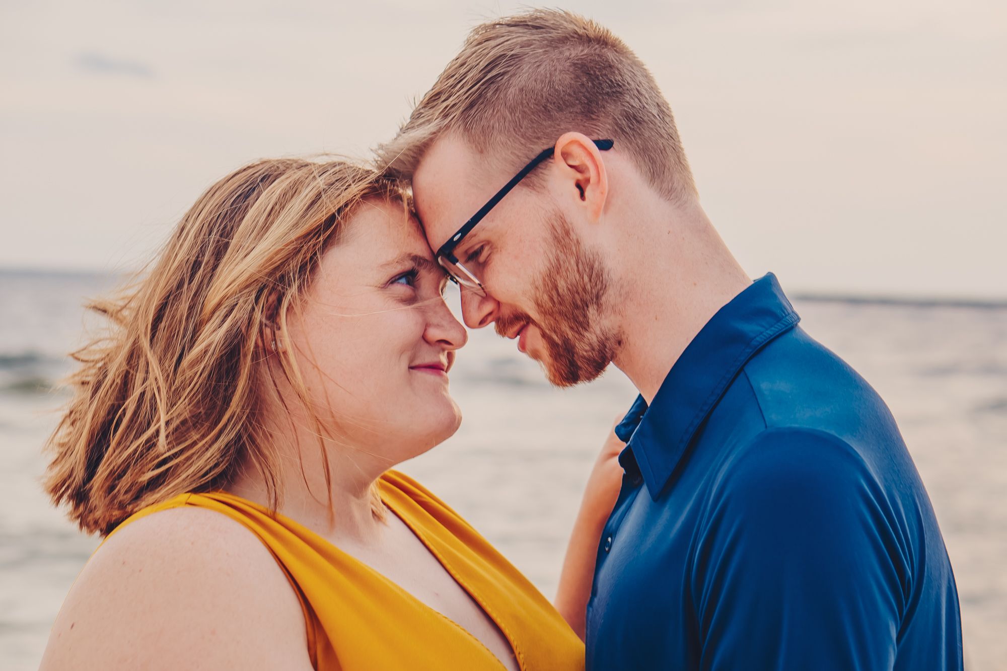 Adorable couple share a loving look with one another on the beach