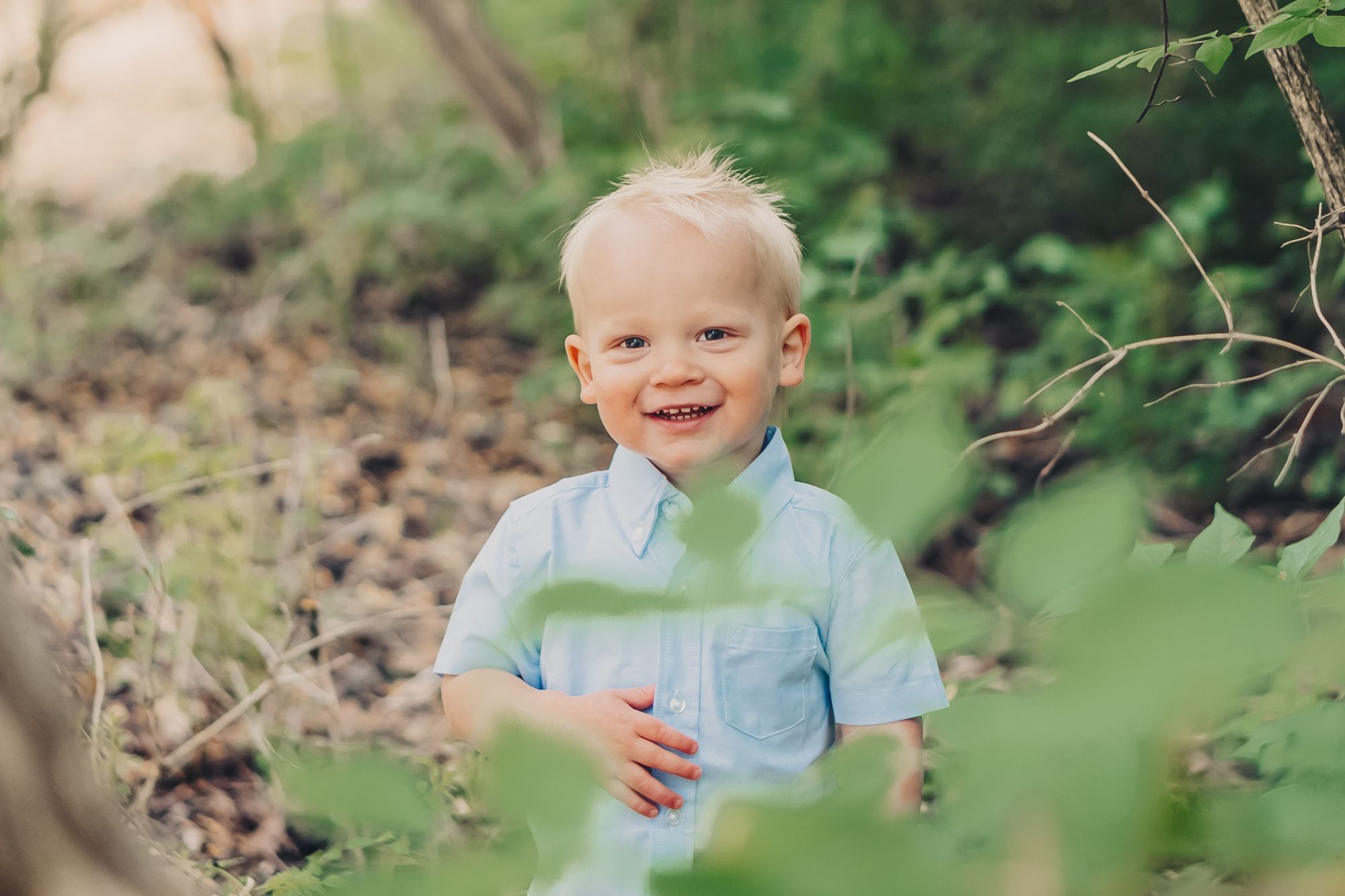 Dreamy light and airy photo of a young boy in a field of green